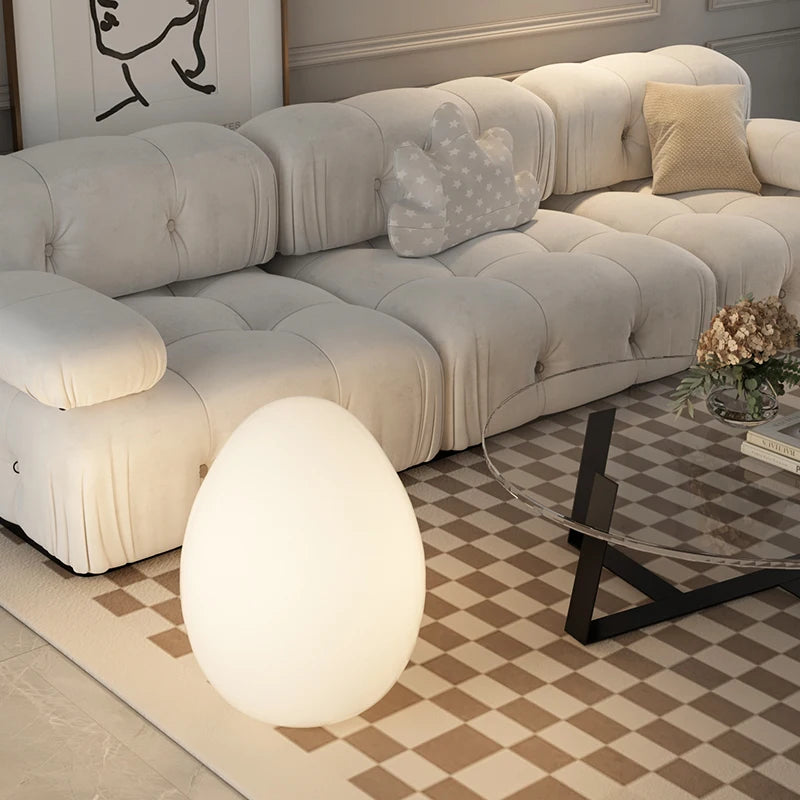 Lampe en forme d'oeuf posée sur le tapis de salon