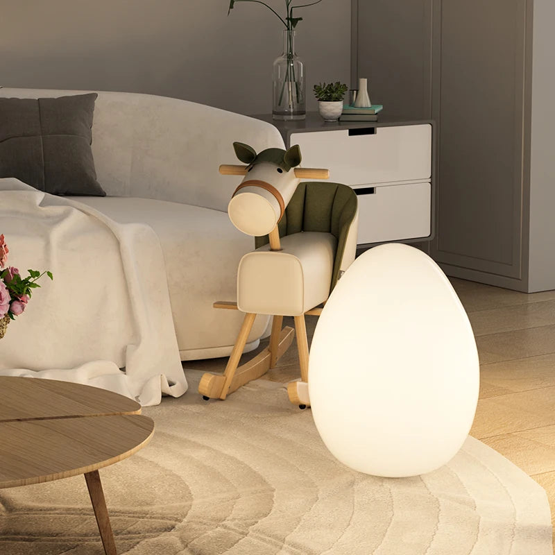 Lampe en forme d'oeuf posée sur  un tapis rond de salon