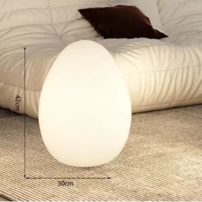 Lampe en forme d'oeuf posée sur le tapis de salon