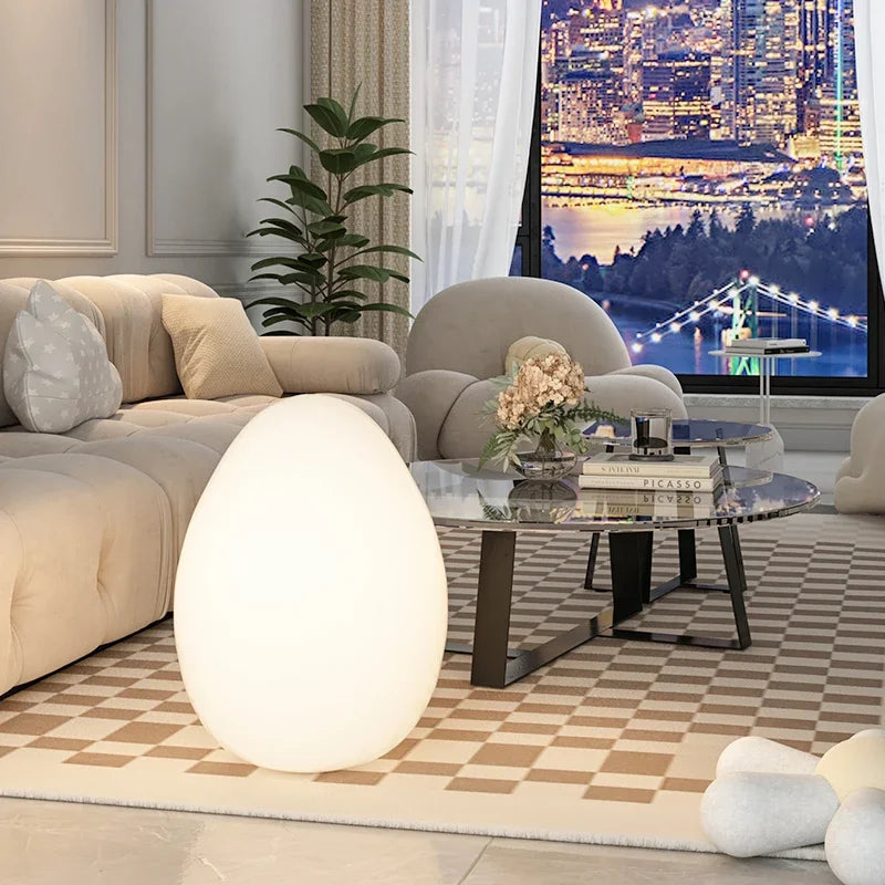 lampe en forme d'oeuf posée sur le tapis en damier du salon